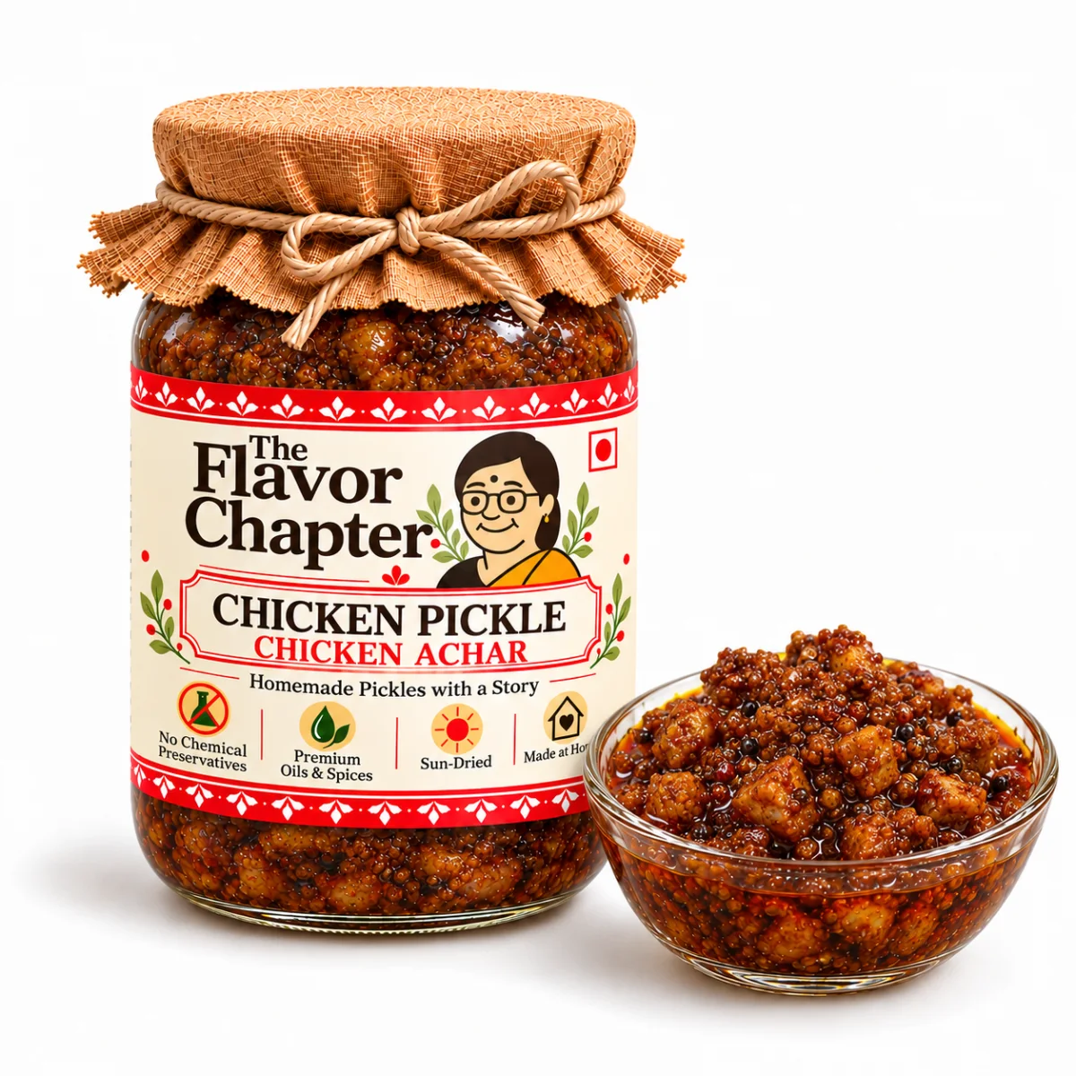 Chicken pickle chicken achar jar with a glass bowl of small boneless chicken pieces in red masala and mustard oil
