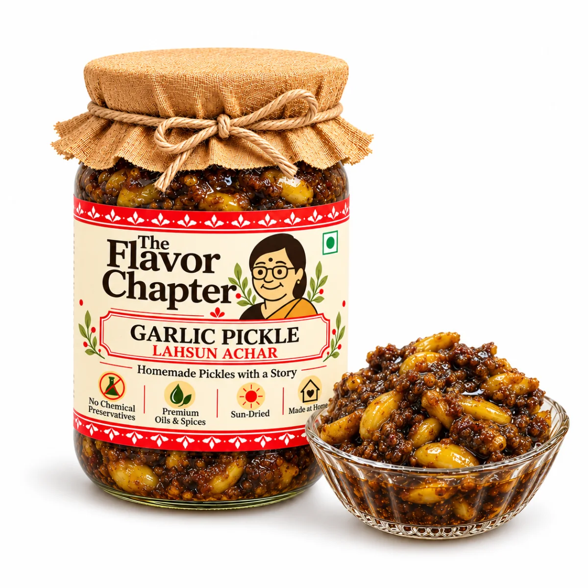Homemade garlic pickle (lahsun achar) in a The Flavor Chapter jar with a bowl of whole garlic cloves in dark tamarind and jaggery masala, on white